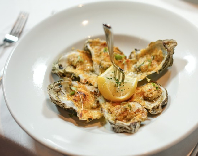 Enjoy the char-grilled oyster appetizer at Criollo Restaurant. (Photo by Paul Broussard)